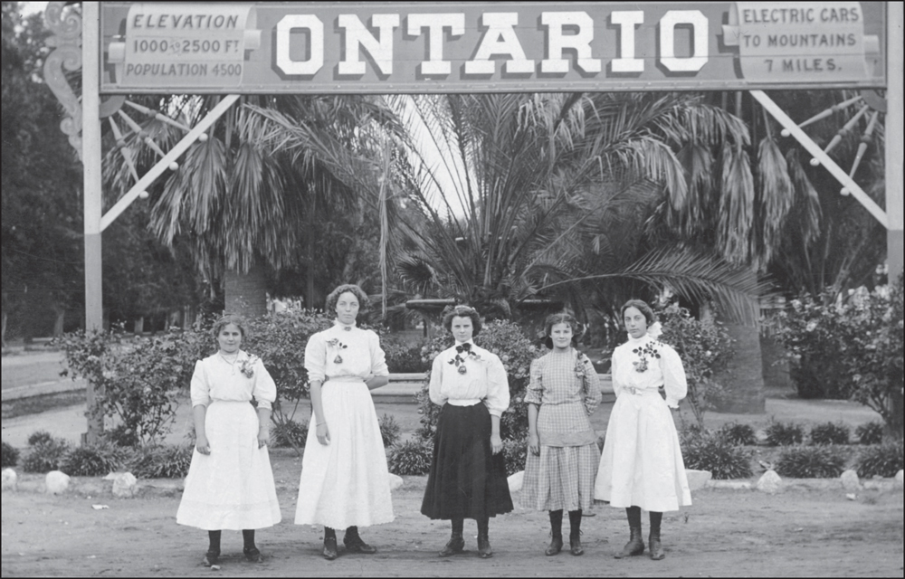 Five young women pose under an Ontario sign advertising electric cars to the - photo 2