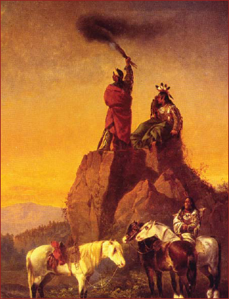 Native American horsemen send a smoke signal from a rocky outcrop by waving a - photo 2