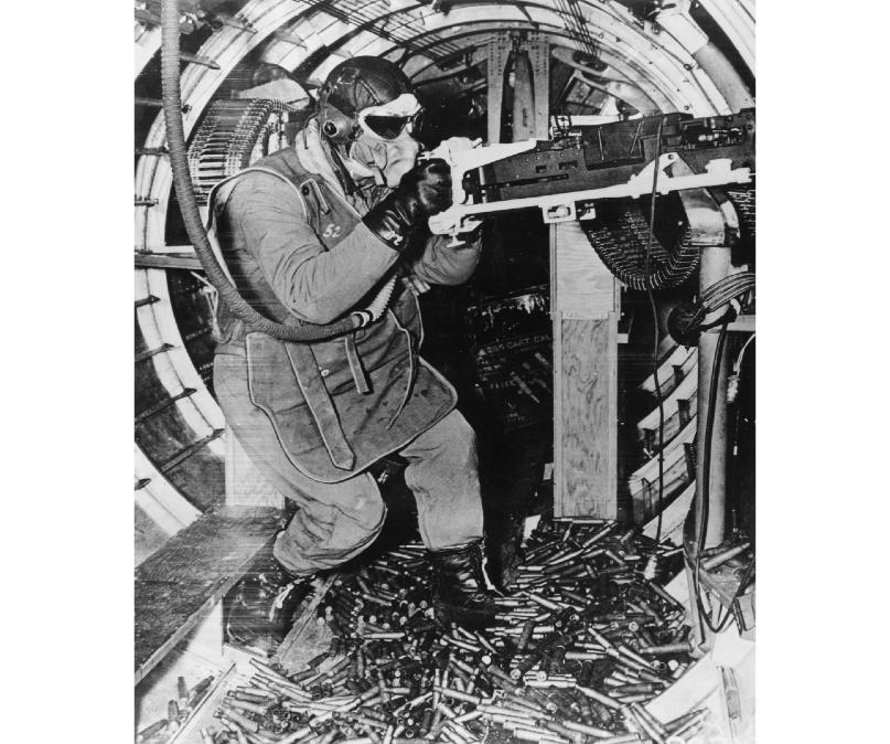 AAF waist gunner equipped with typical flight gear in action aboard a B-17 - photo 1