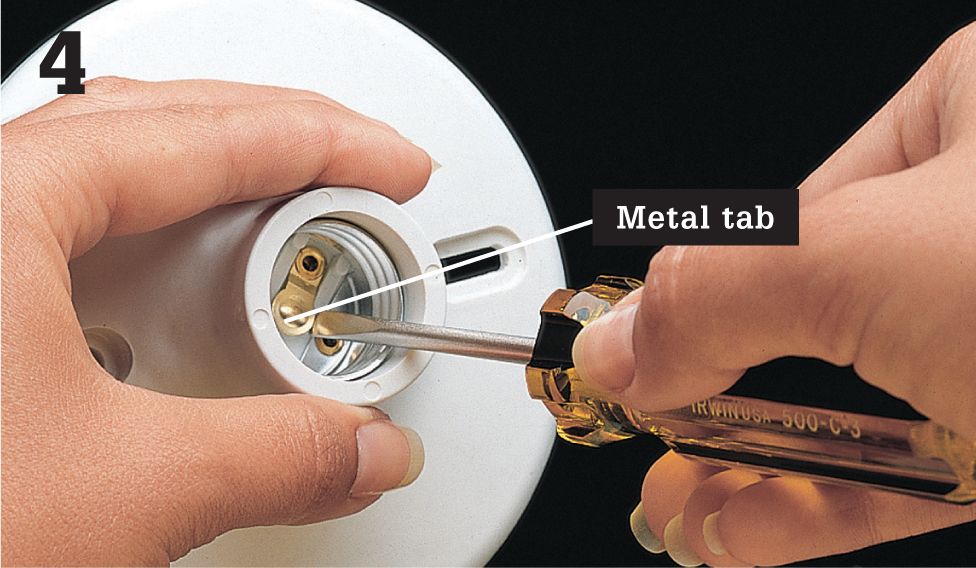 Adjust the metal tab at the bottom of the fixture socket by prying it up - photo 13