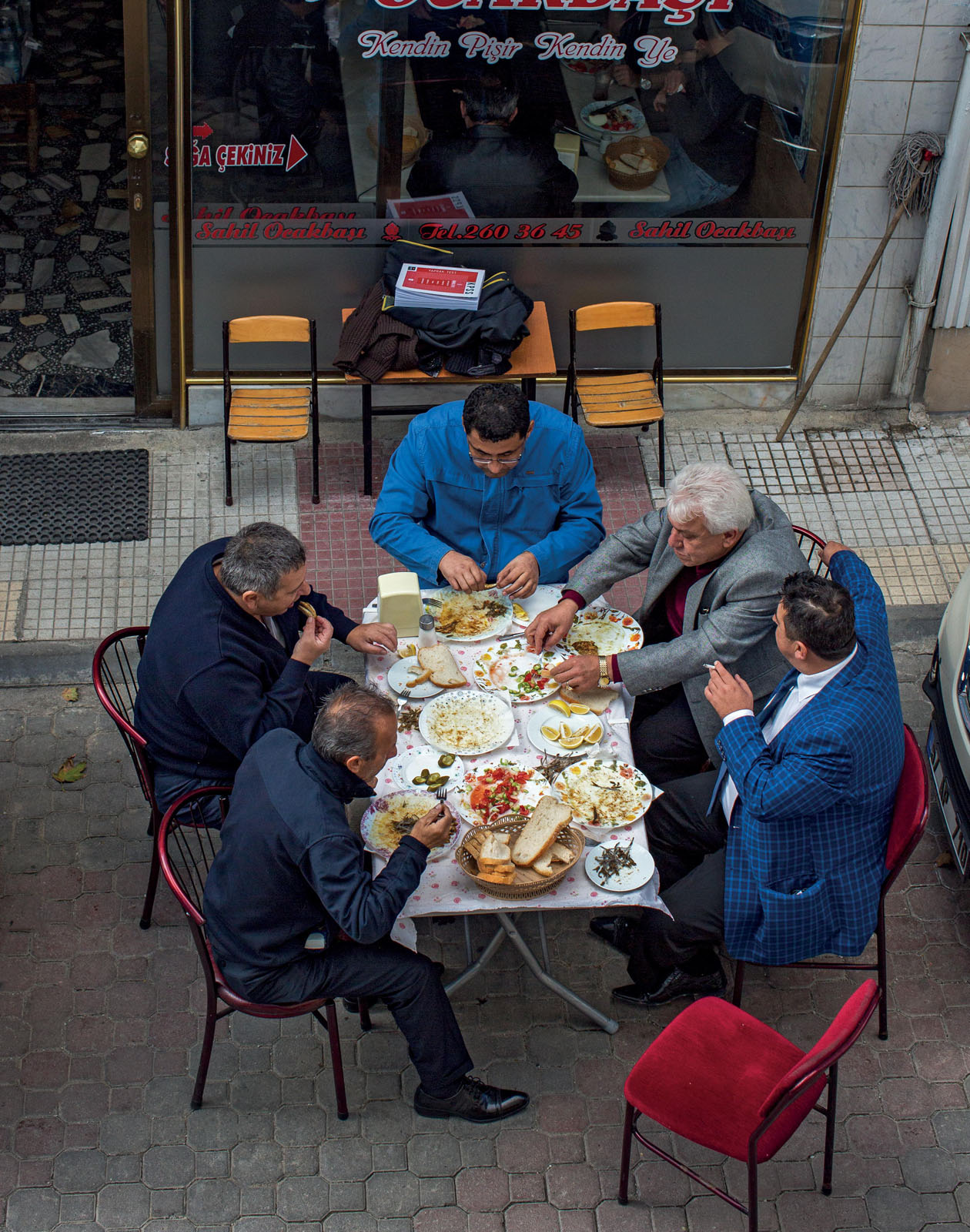 Friends lunch on grilled anchovies in front of a restaurant on the Black Sea - photo 10