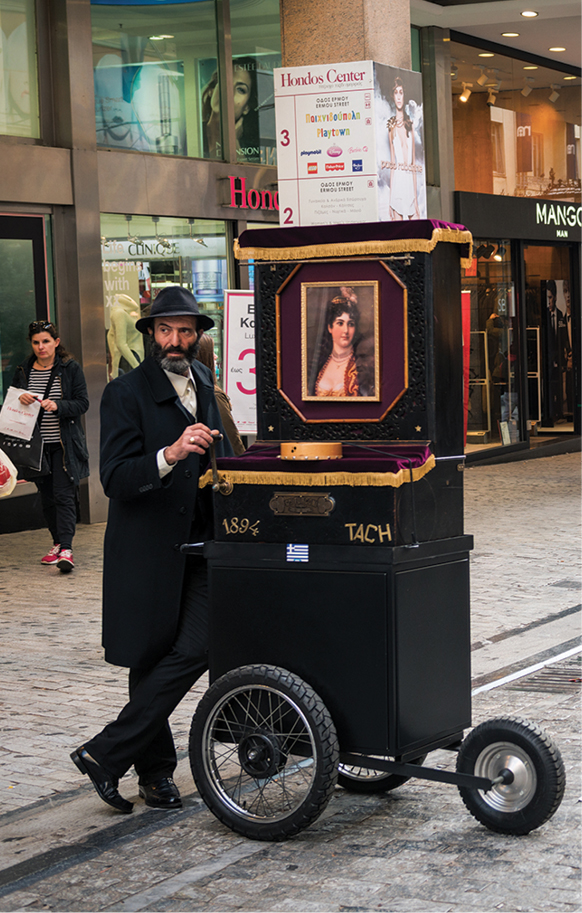 A traditional organ grinder plies his ages-old trade on an upscale shopping - photo 10