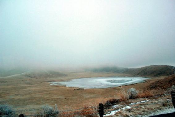 Higher up in elevation this pond stands frozen surrounded by for and smoke - photo 4