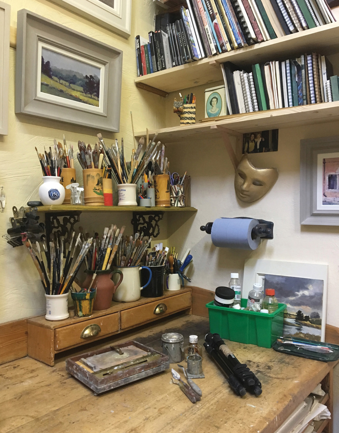 An organized corner of the studio with sketch books and brushes on shelves - photo 6