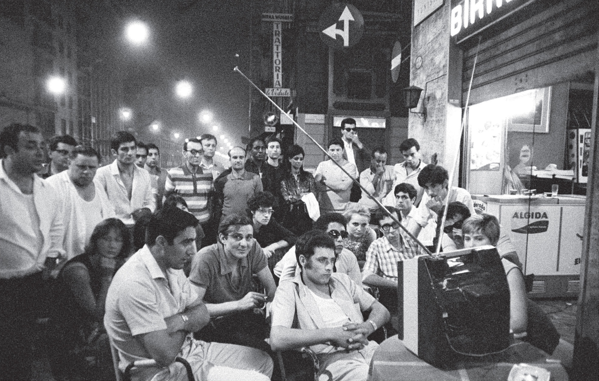 A small television at an outdoor sidewalk caf in Milan Italy draws a large - photo 4