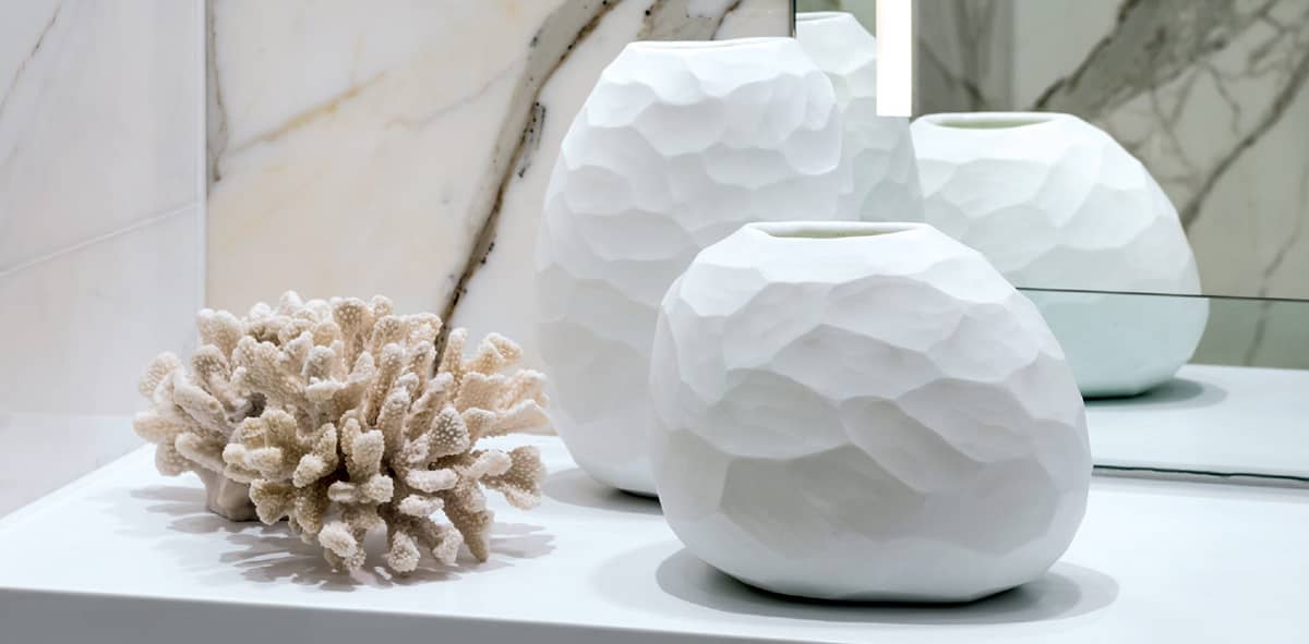 Chalky white ceramic vases and resin coral are displayed on a Corian bathroom - photo 6