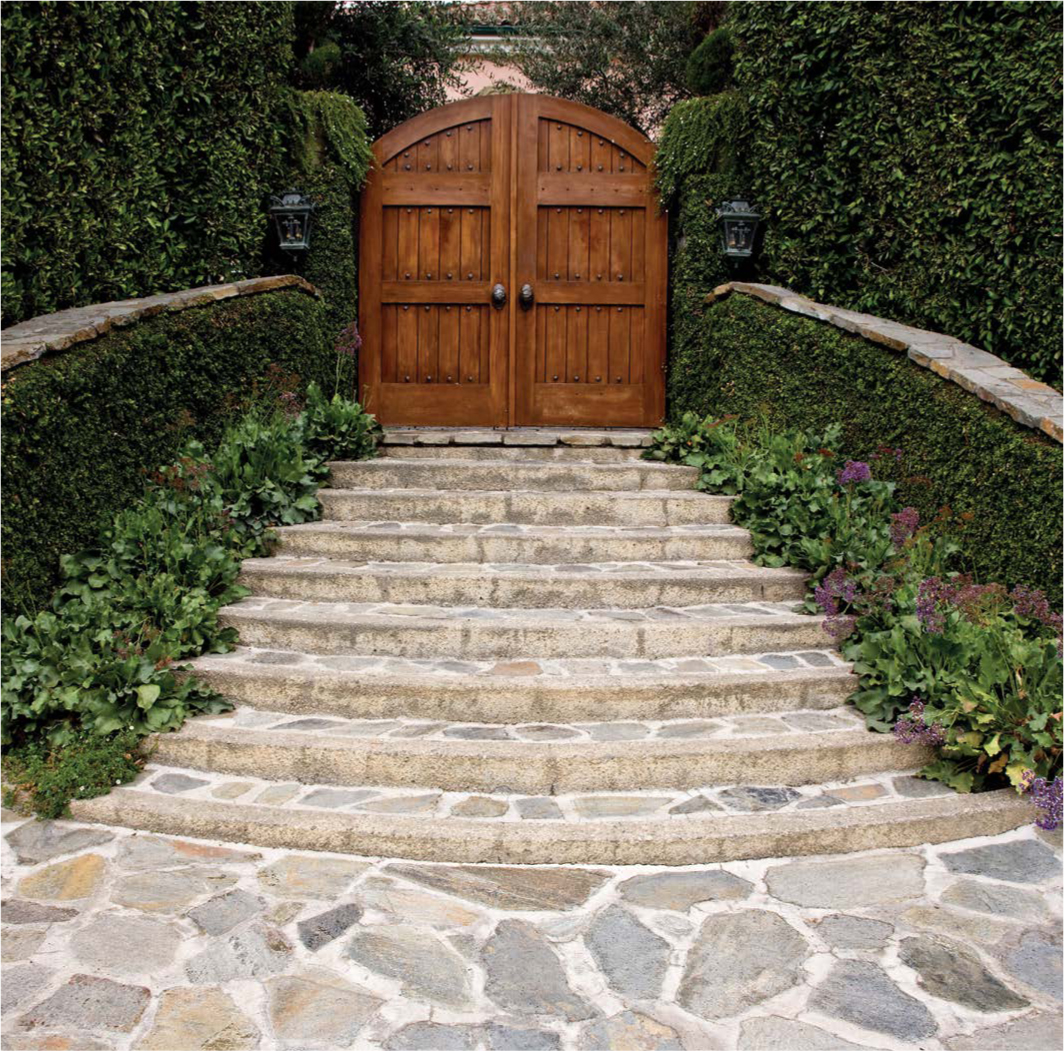 Mortared flagstone steps lead up to rustic wood doors at this California homes - photo 8