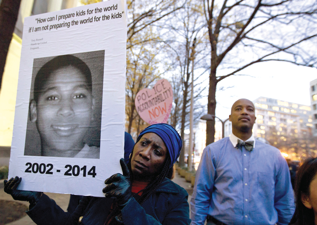 Demonstrator Tomiko Shine center holds a picture of twelve-year-old Tamir - photo 4