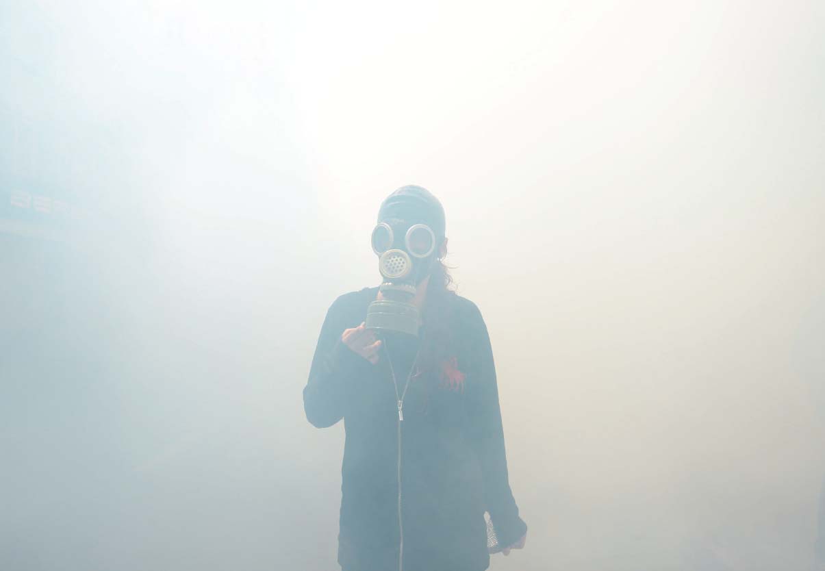 A protester in Istanbul walks through tear gas clouds with a gas mask A man - photo 18