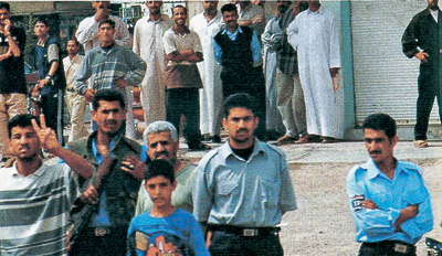 Fallujahan residents stare impassively at the camera while three blue-shirted - photo 3