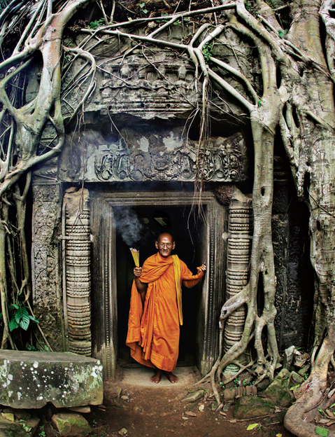 A Buddhist monk burns incense of the ages in the ruins of Cambodias revered - photo 6