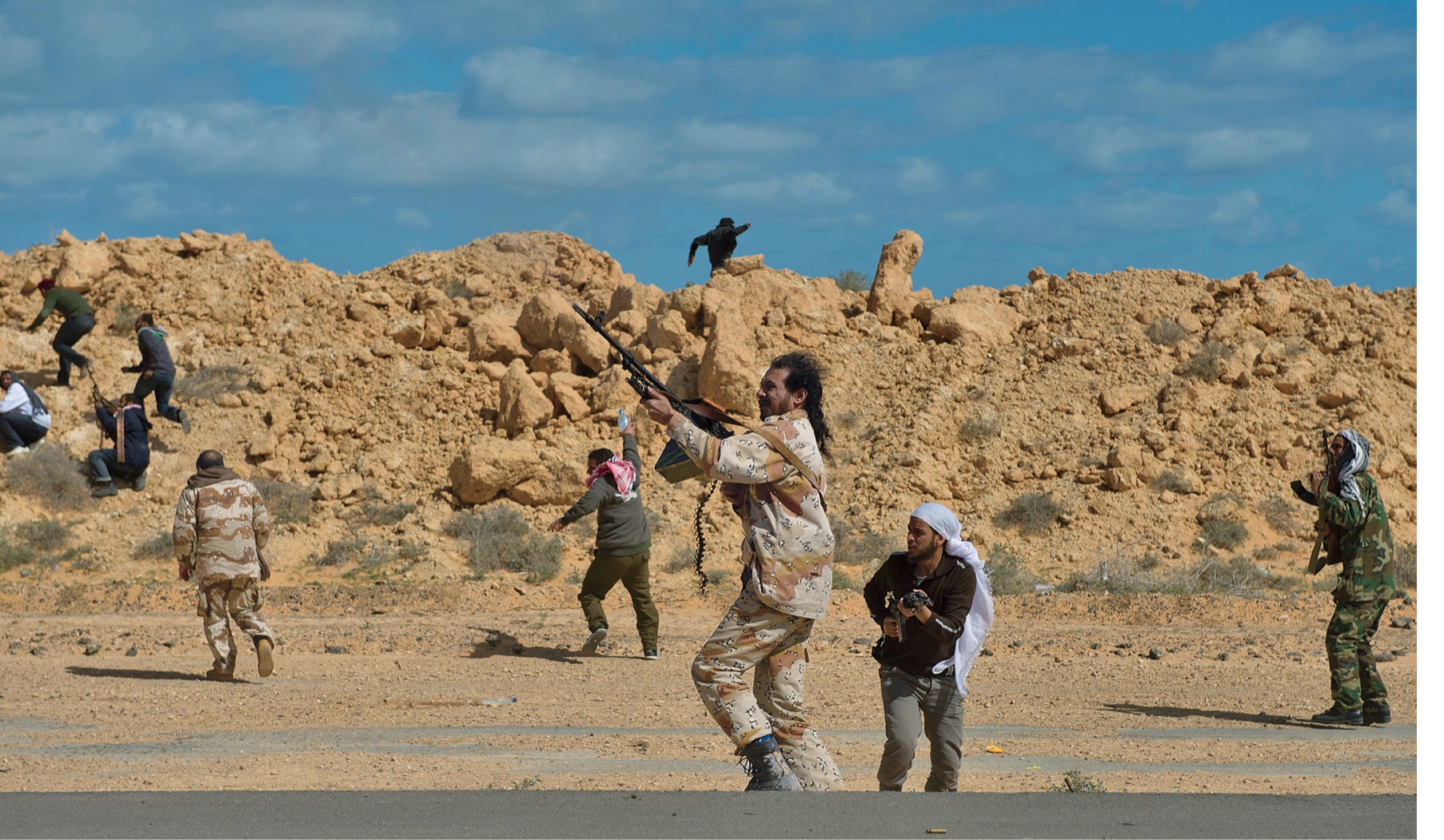 Opposition troops fire at a government helicopter as it sprays the area with - photo 5