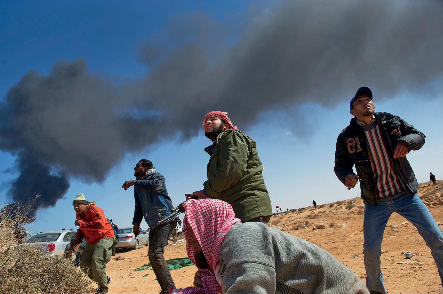 Rebel fighters and drivers look up into the sky in anticipation of a bomb and - photo 8