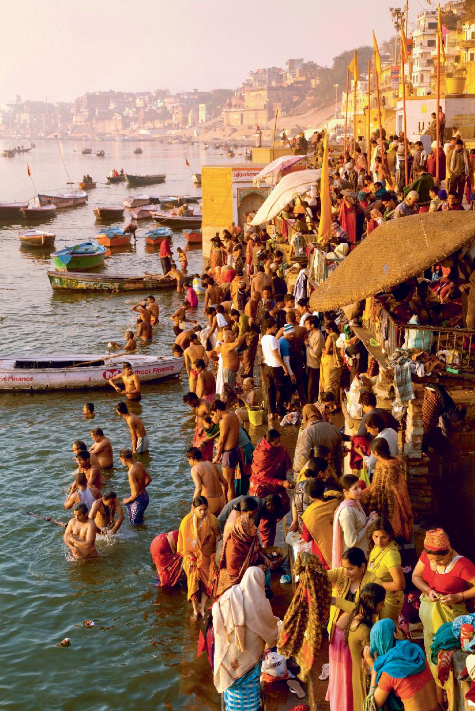 Sunrise at the Harischandra Ghat at Varanasi on the Ganges with bathers facing - photo 1