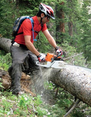 A volunteer works to clear the trail Hundreds of fallen trees are removed - photo 7