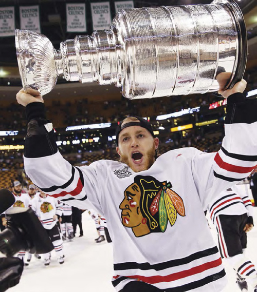 Right wing Patrick Kane raises the Stanley Cup in triumph after his teams - photo 8