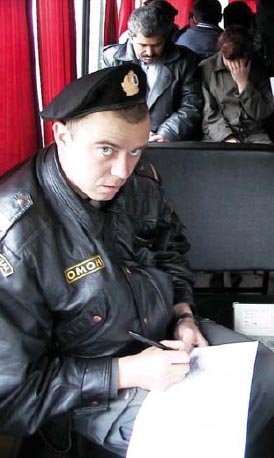 Police junior NCO processing prisoners inside a bus after a mass arrest in - photo 11