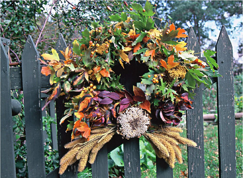 A round wire wreath form is covered in oak maple and forsythia leaves with - photo 5