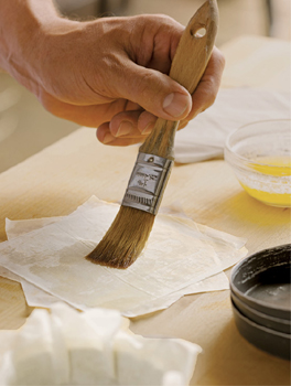 Squares of store-bought filo dough are brushed with butter for Desserts at - photo 7