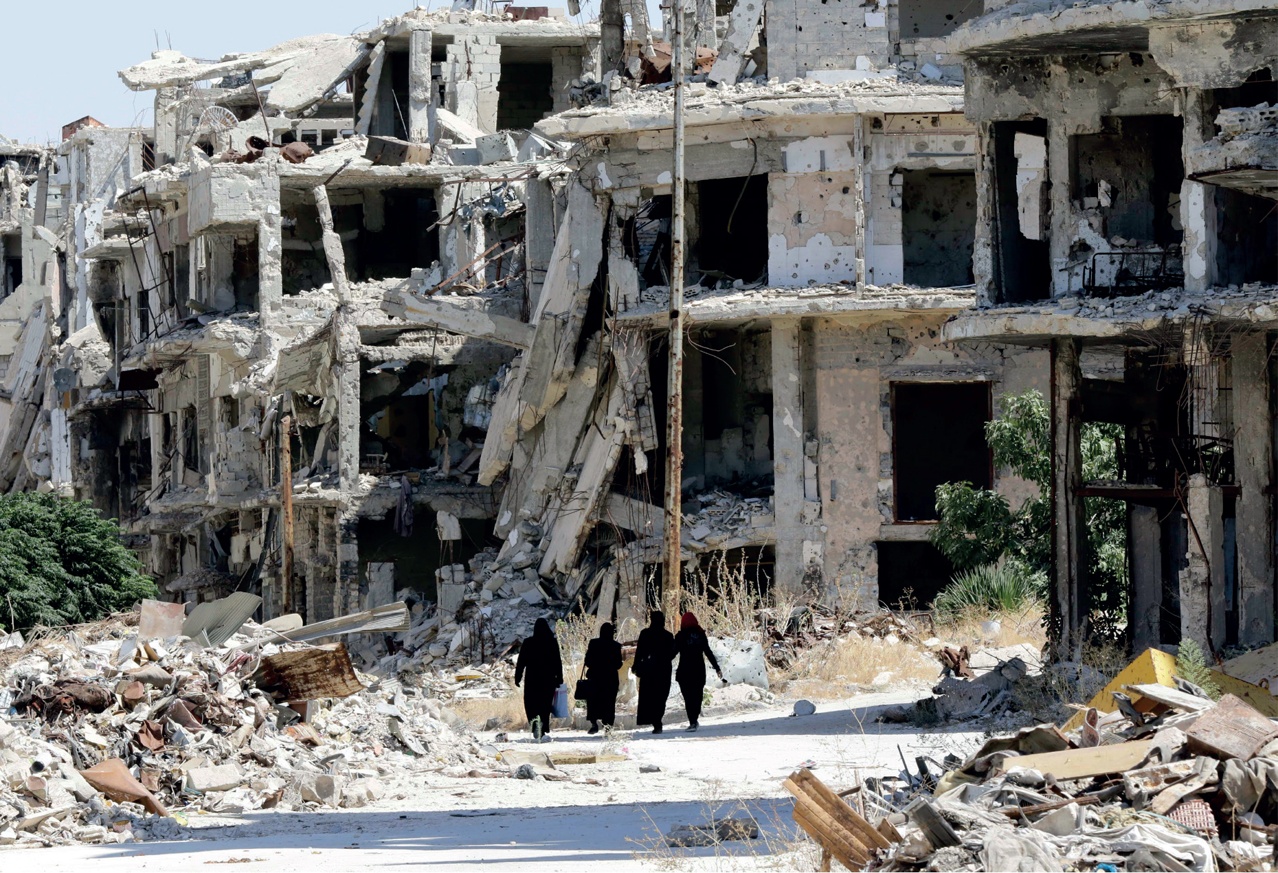 Women walk between destroyed buildings in the government-held Jouret al-Shiah - photo 5