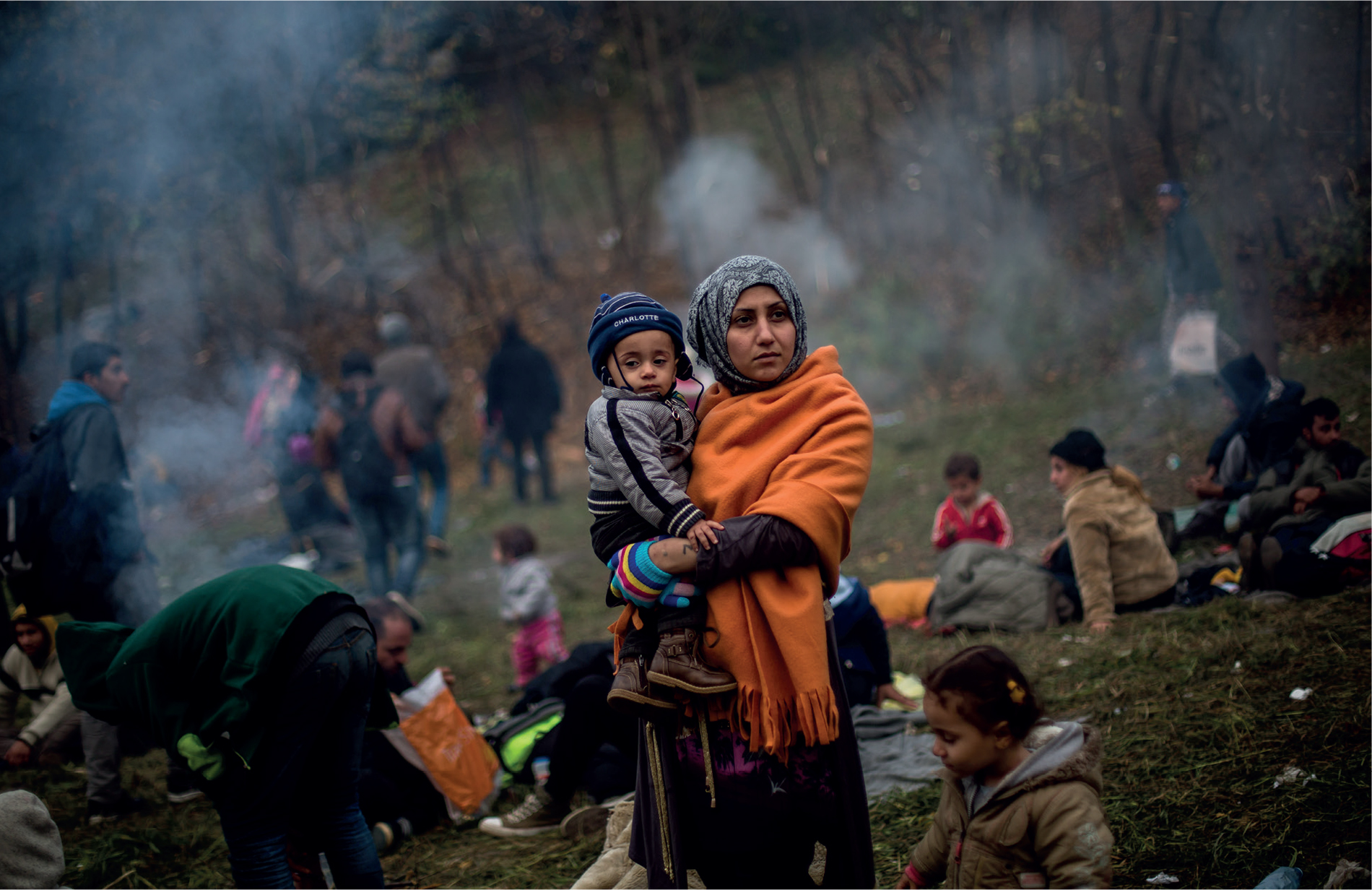 A woman and child refugee from Syria wait at the border to Austria in Sentilj - photo 18