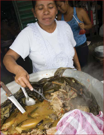 A Native American woman from Nicaragua cooks beef with local vegetables yucca - photo 2