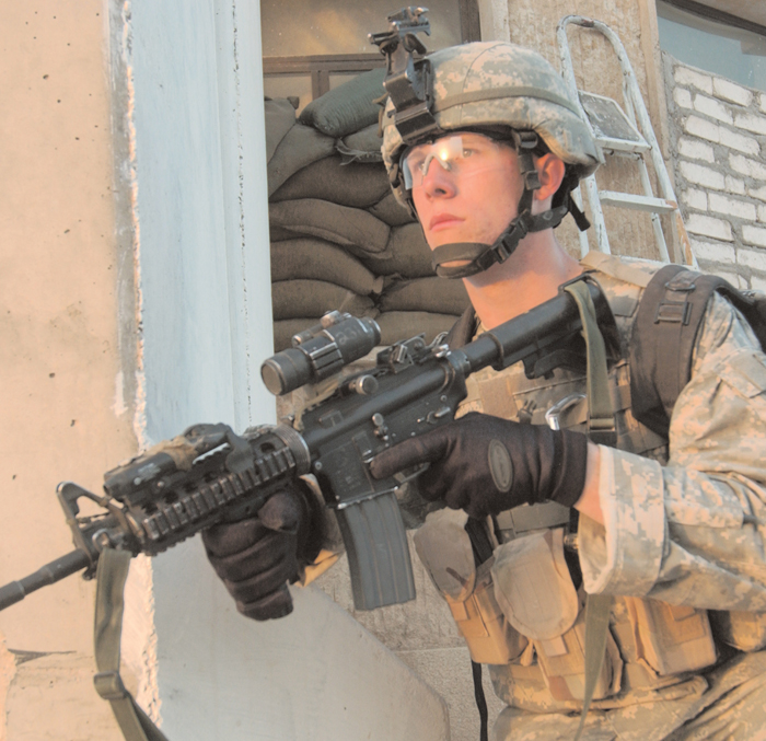 A US soldier on patrol In Mosul Iraq scans the street warily his M4 carbine - photo 2