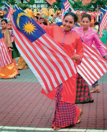 Dancers holding the Malaysian flag at the annual National Day parade in - photo 6