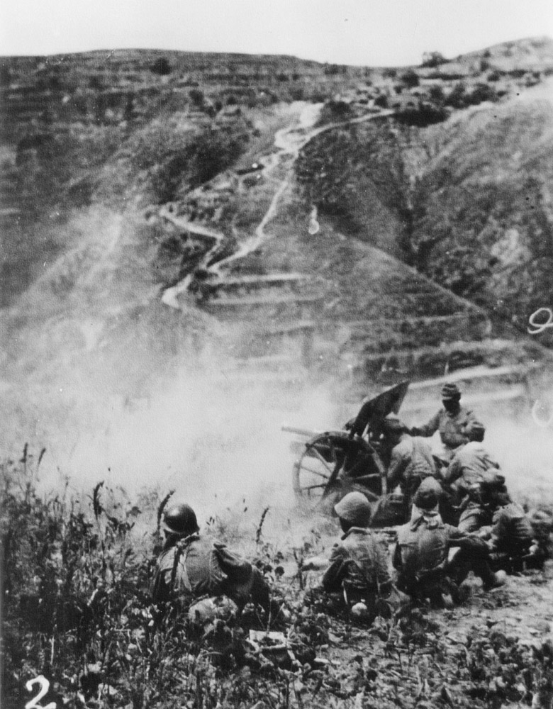 A Japanese army mountain gun is fired by its crew during fighting in the hills - photo 3