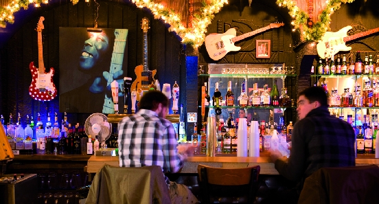 Customers sitting at bar with guitars and photo of Buddy Guy behind bar of - photo 6