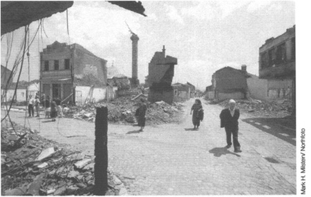 Kosovo Albanians survey the centre of Djakovica days after Yugoslav army and - photo 11