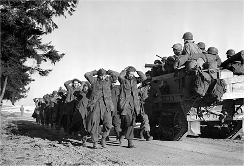 A 4th Armored Division half-track passes German POWs on a road south of - photo 16