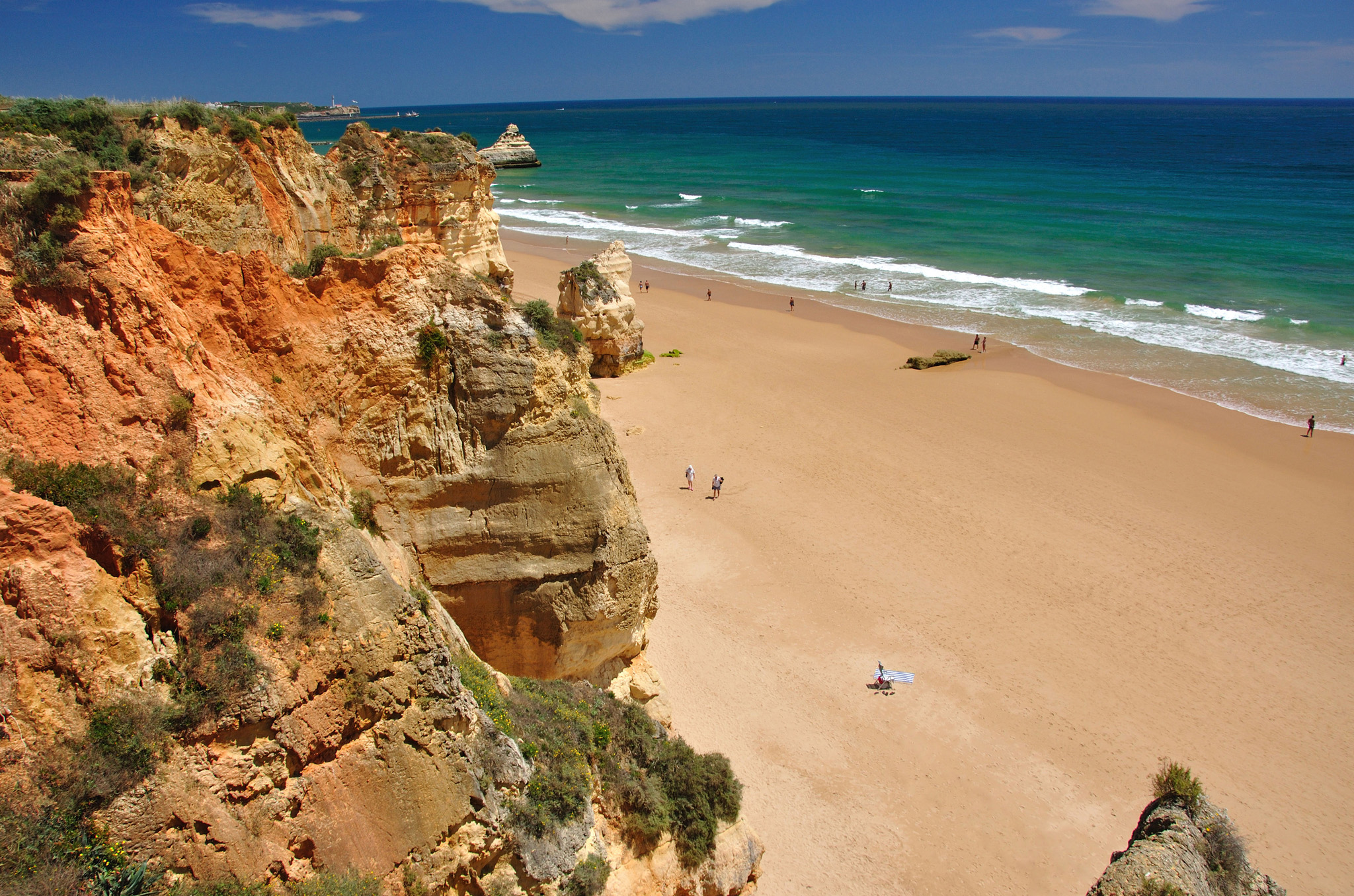 A vast swathe of golden sand is set against dramatic multicoloured cliffs at - photo 6