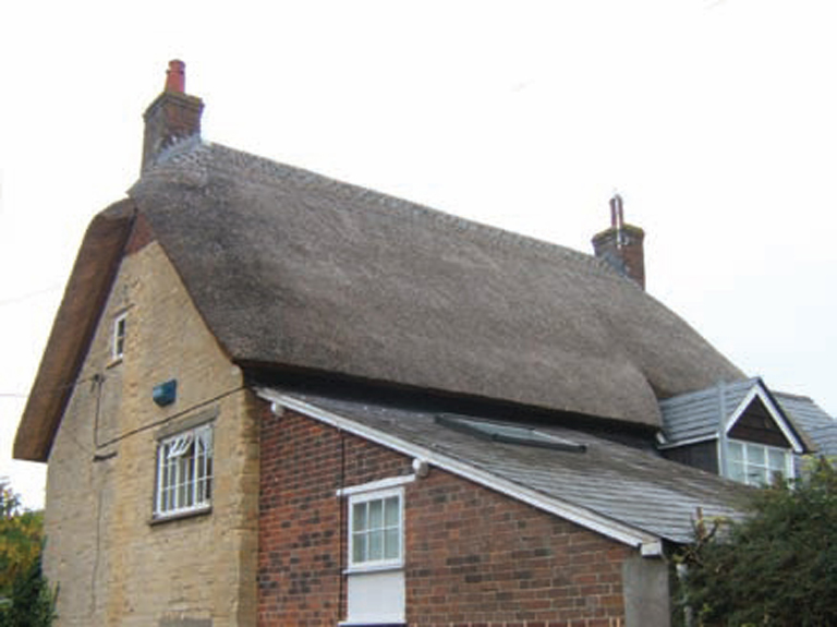 Here the thatch overshoots the gable end forming broad shoulders separated by a - photo 2