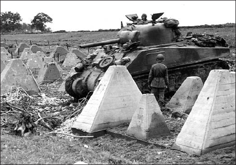 A pair of GIs take cover from the incessant rain under the rear of an M4 tank - photo 3