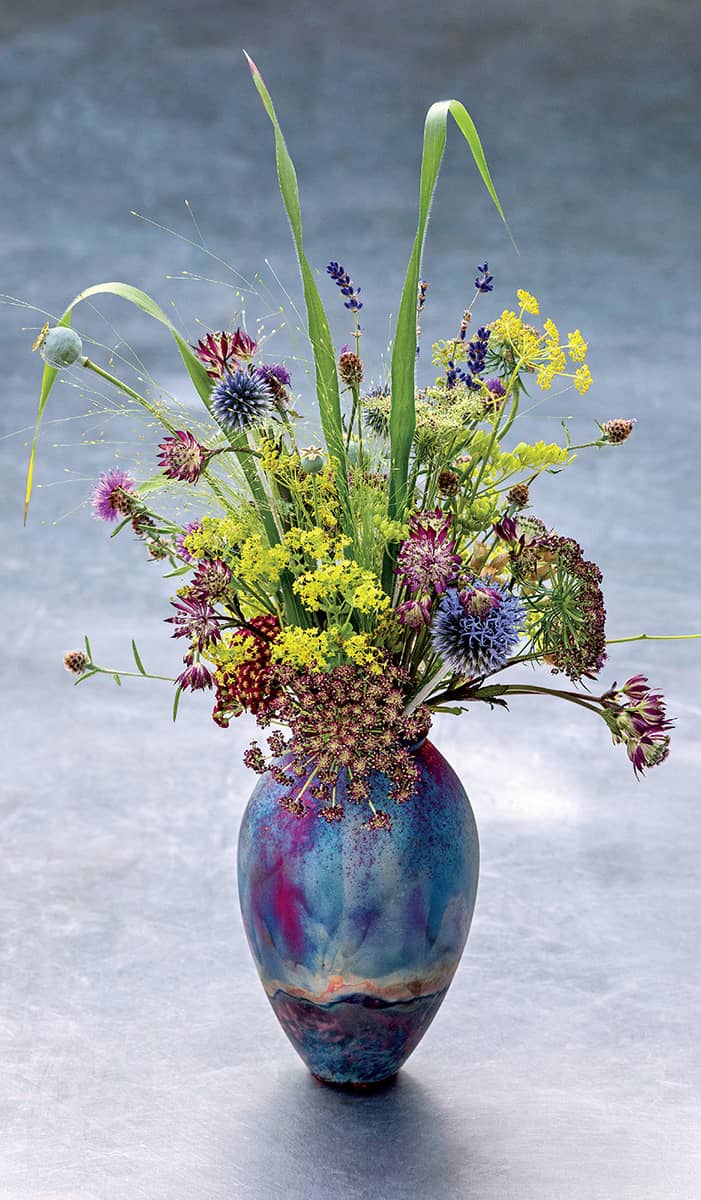 A Raku vase is filled with poppy seedheads Daucus carota the field scabious - photo 13