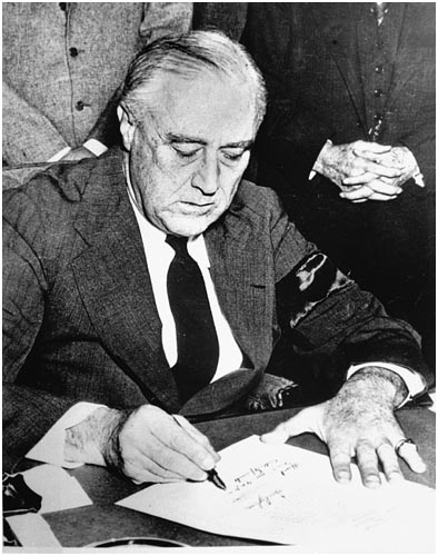 Wearing a black armband President Franklin D Roosevelt signs a declaration of - photo 7