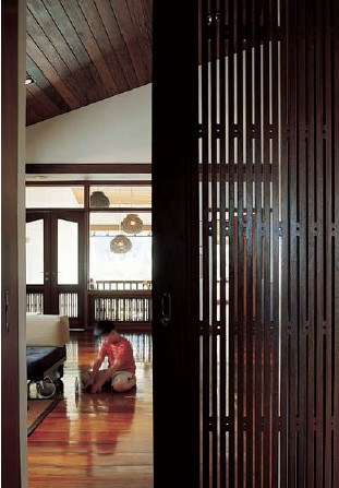 A contemporary linear woodwork screen becomes the sliding door panel between - photo 8