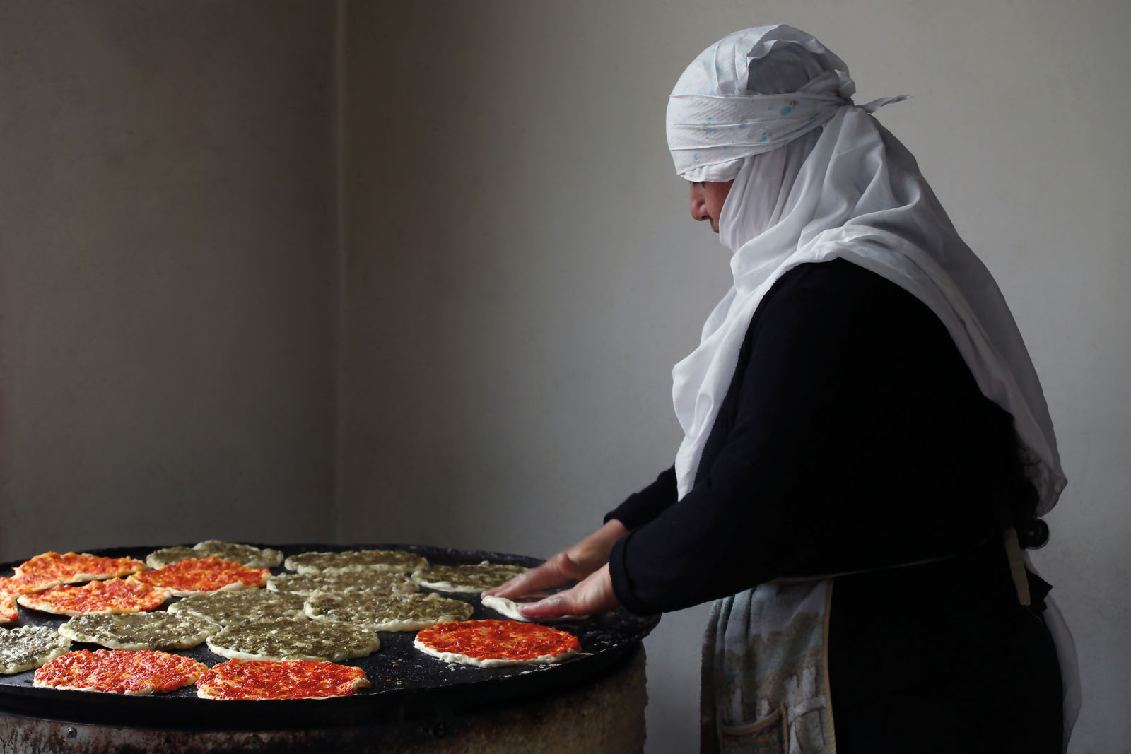 A baker preparing manakish on the saj at Hagolan Bakery in Majdal Shams - photo 4