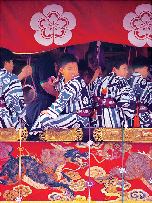 Boys in festival attire ride atop a yama pull-style float Young taiko - photo 15