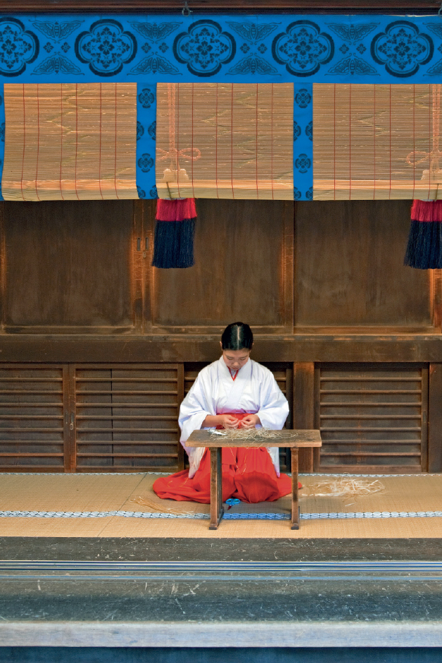 A miko shrine maiden making traditional hair ribbons A vermilion path of - photo 6
