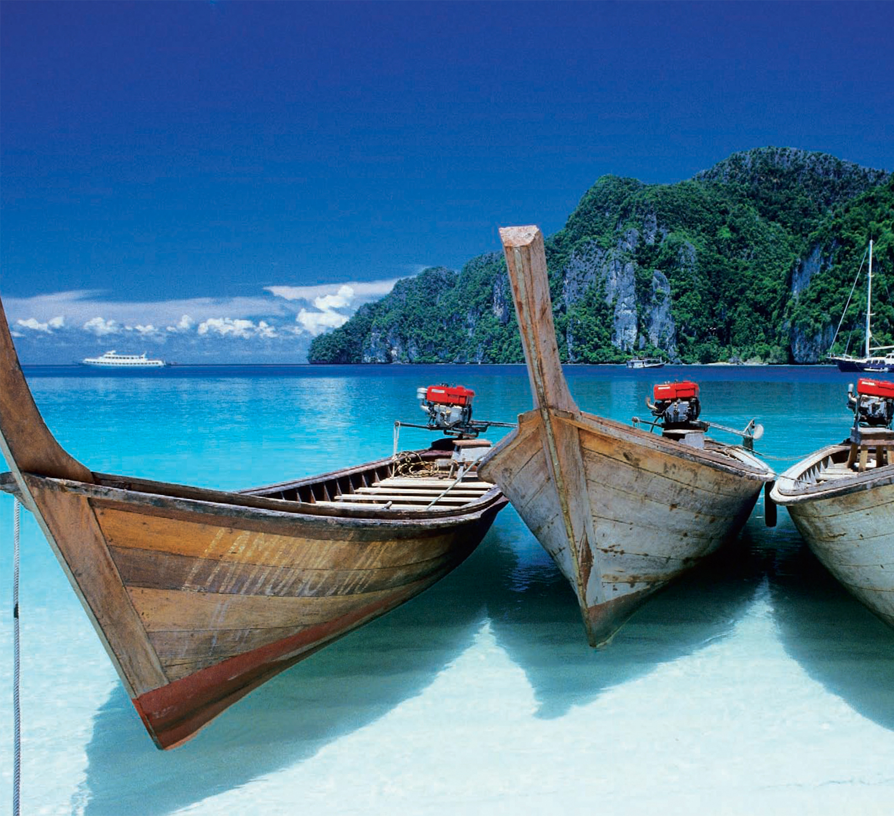 Traditional longtail boats sit at anchor in the turquoise waters of the Andaman - photo 6