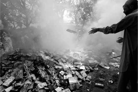 8 CDs and DVDs are consigned to the flames by a student of the Lal Masjid Red - photo 12