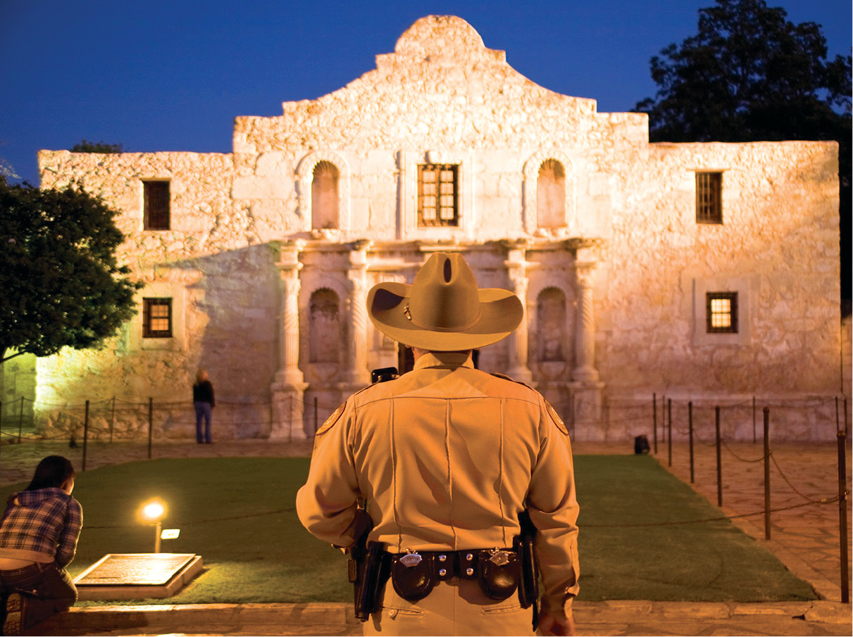 A local sheriff stands at attention before the Alamo mission site of the famed - photo 11