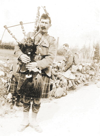 A piper of the 14th Seaforth Highlanders plays during a roadside break July - photo 5