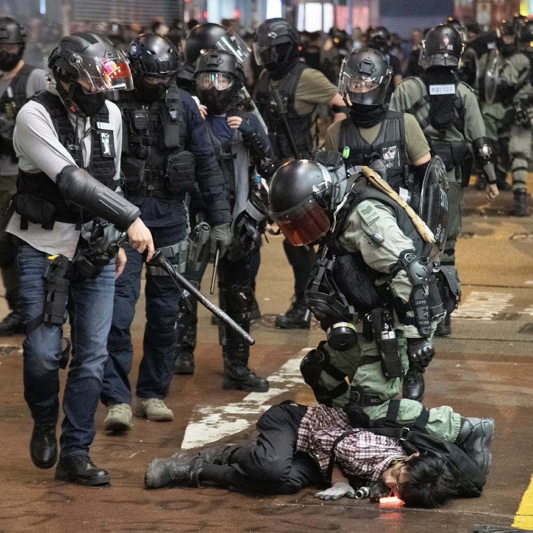 In the Mong Kok area of Hong Kong a police officer kneels on the back of a - photo 5