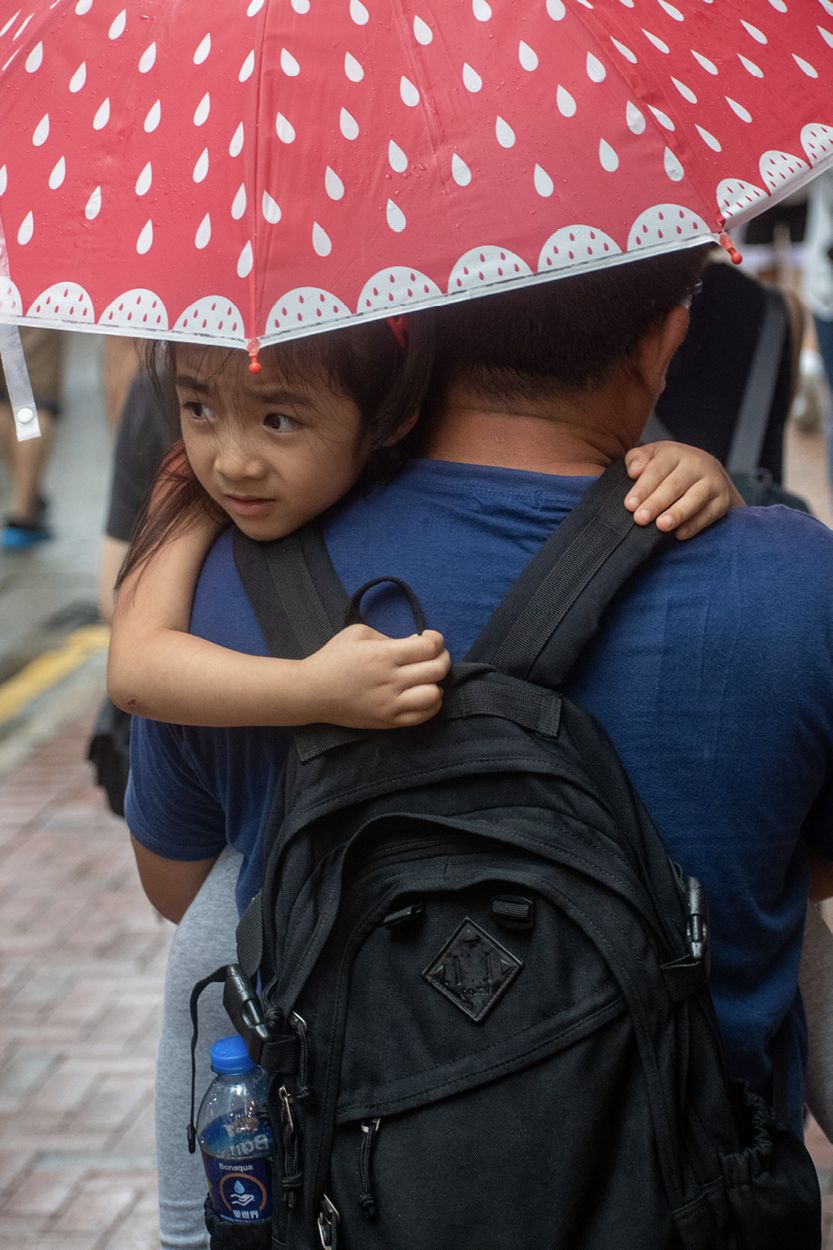 A young girl looks out at a crowd of thousands of protesters on Hennessy Road - photo 15