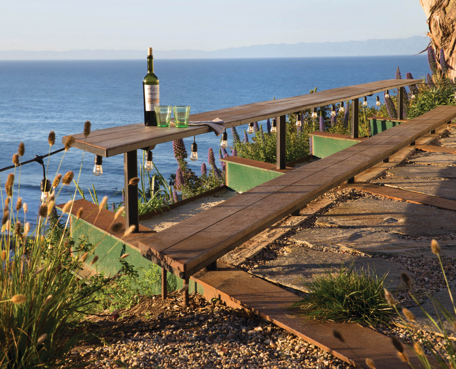 A narrow biergarten-style table and bench are suspended over the cliffsedge - photo 10