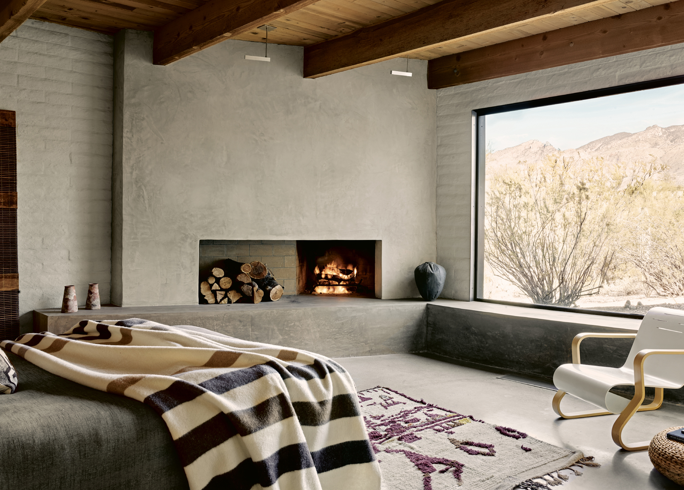 The sunken master bedroom has a coziness accentuated by the concrete fireplace - photo 8