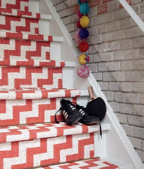 A woven plastic stair runner in red and white zigzags provides a playful - photo 14